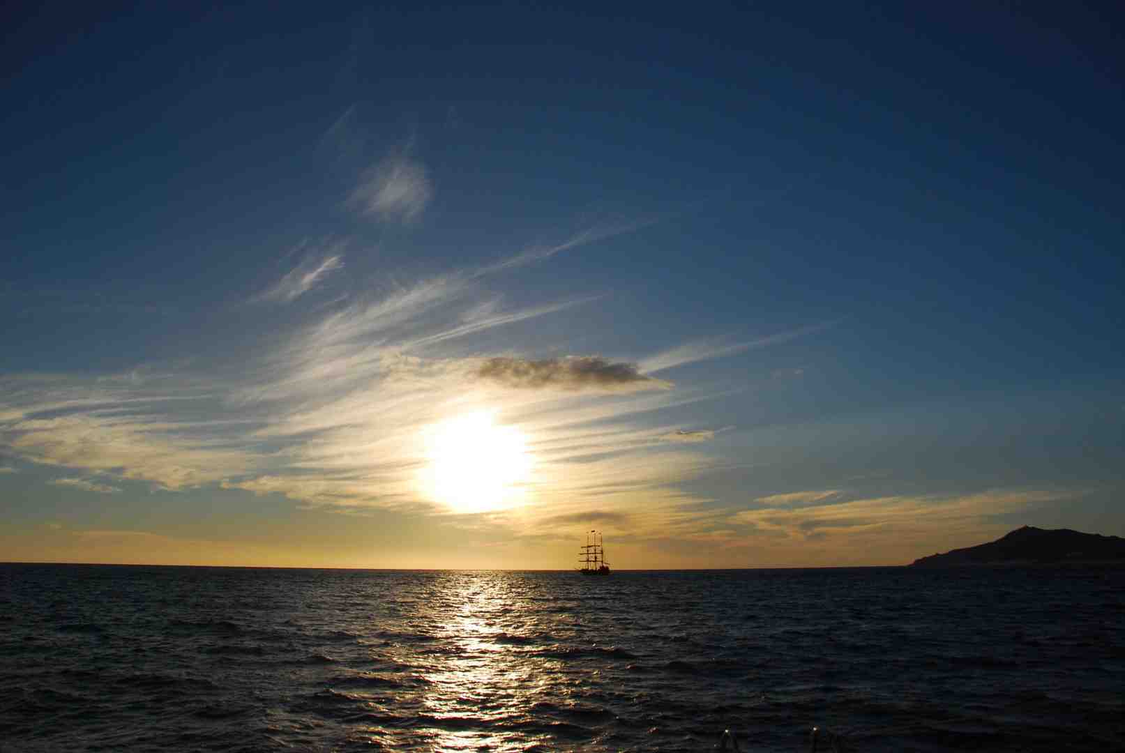 sunset catamaran cruise with vibrant orange sky - things to do in cabo