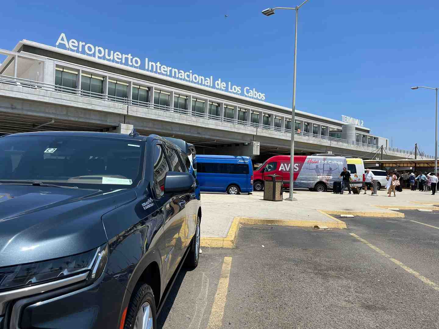Family loading luggage into a private SUV at SJD Airport - transporte aeropuerto san jose del cabo